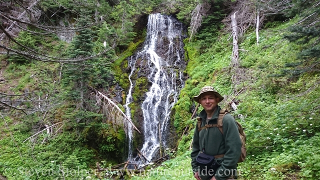 hiker in front of waterfall at Olympic National Park