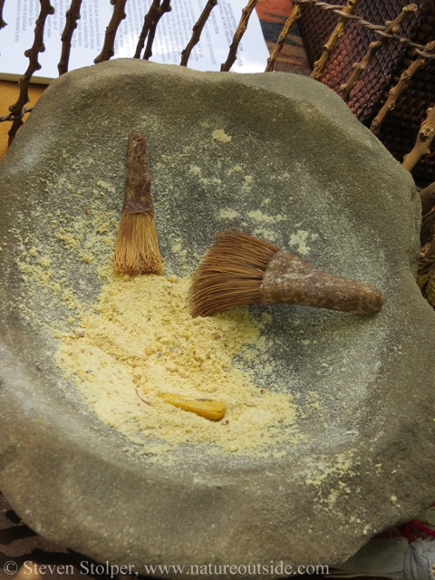 Stone mortar and soaproot brushes with acorn meal.