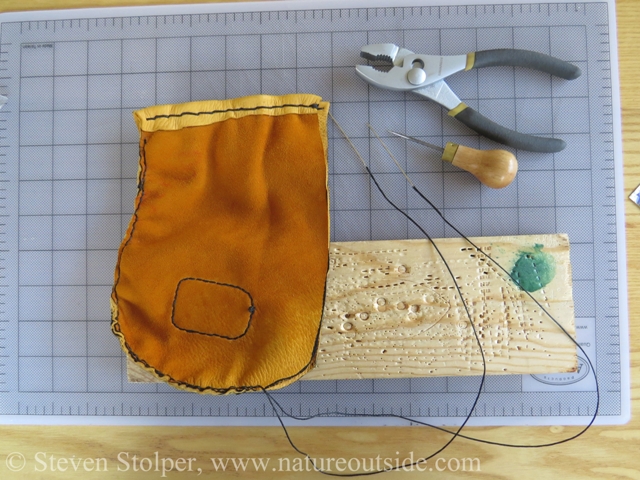 Stitching progresses around the circumference of the pouch.