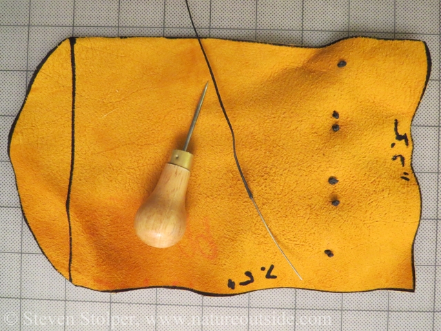 The back of the bag after the beads attached. The beads are longer than the space between pairs of dots. Pictured is the awl, harness needle, and waxed nylon thread.