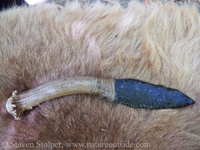 Flint blade attached to deer antler handle. Bound with artificial sinew. Knife by Wayne Powers.