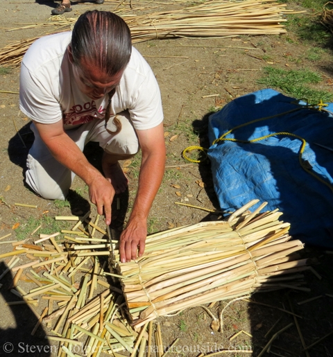 Trimming the ends of a tule mat with a knife.