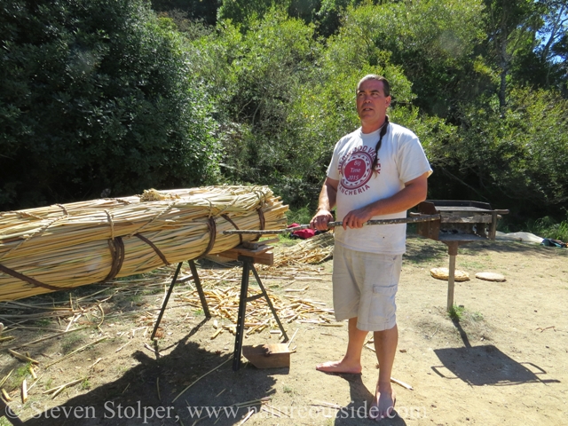 Positioning the hazel rod prior to hammering it into the boat.