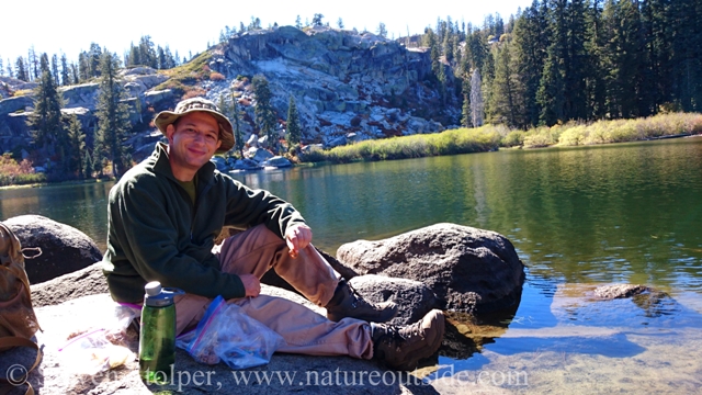 hiker resting on rock at flora lake