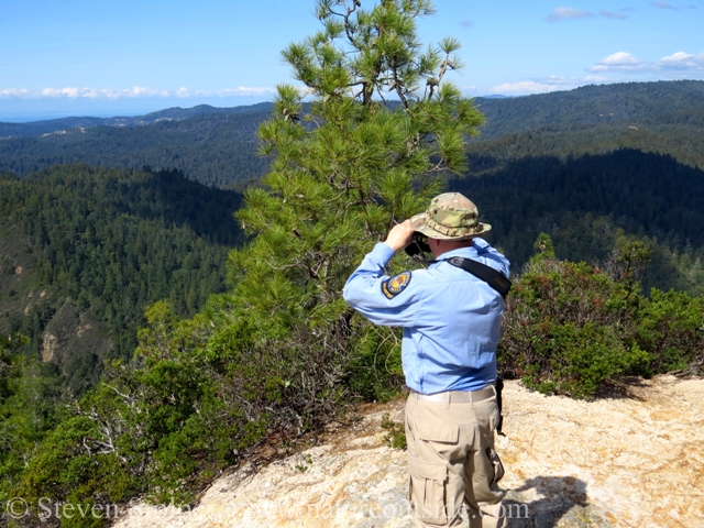 hiker on mountain top looking through Nikon Monarch 5 8x42 binoculars