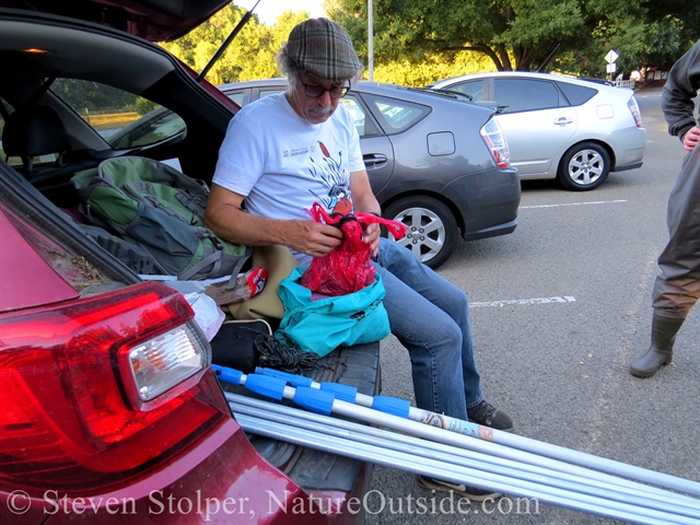 Unloading the poles and nets. The nets are in the plastic bags.