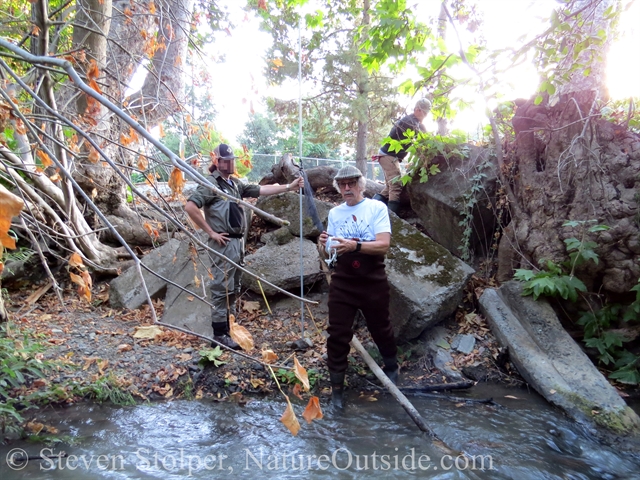 Dave unspools the netting as he crosses the creek