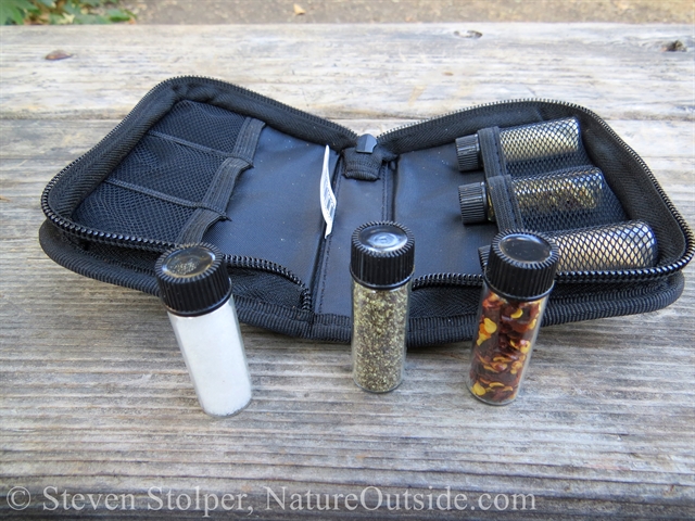 Vials in front of spice kit: Salt black ground pepper, and hot red pepper.