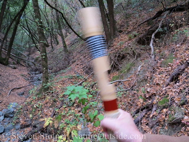 playing clapper stick by holding upright and shaking