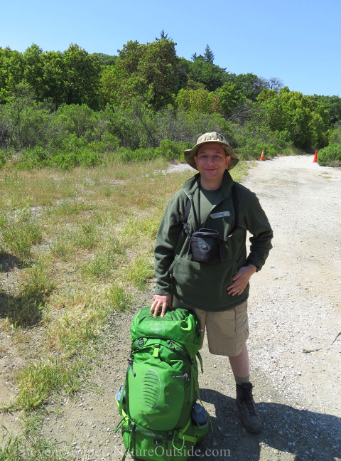 backpacker standing next to backpack