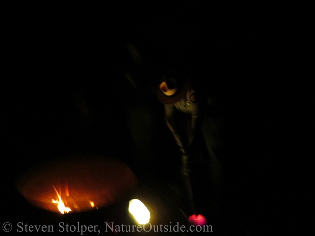 Ranger dunks rock into a basket of water to remove the ash from the fire