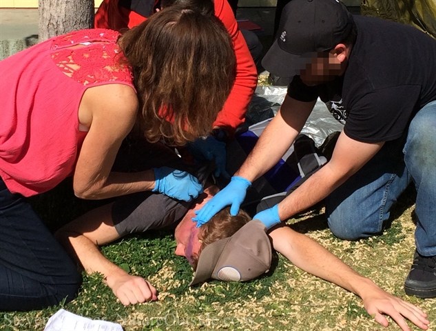 wilderness first aid students examine patient