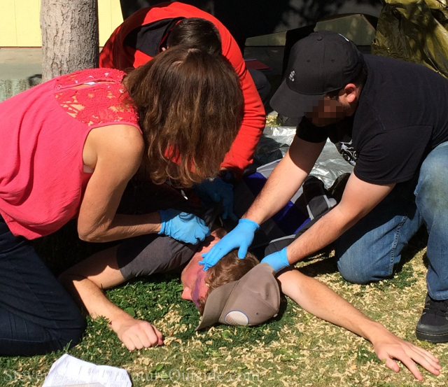 wilderness first aid students examine patient