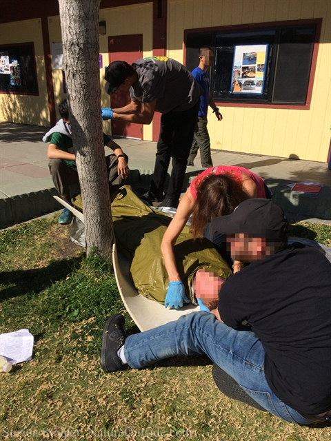 wilderness first aid students examine patient