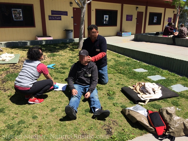 wilderness first aid students examine patient