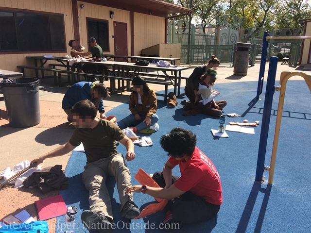 wilderness first aid students examine patient