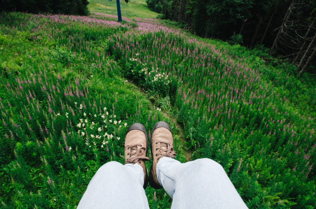 boots dangling over meadow